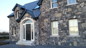 House and garage built with natural stone | Cut granite archway